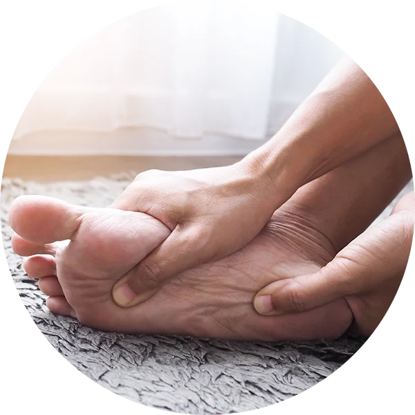 Hands holding the foot to illustrate weakness or reduced sensation in the leg due to sciatica.