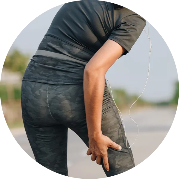 Person bending with hand on lower back to represent recurring sciatic pain episodes.