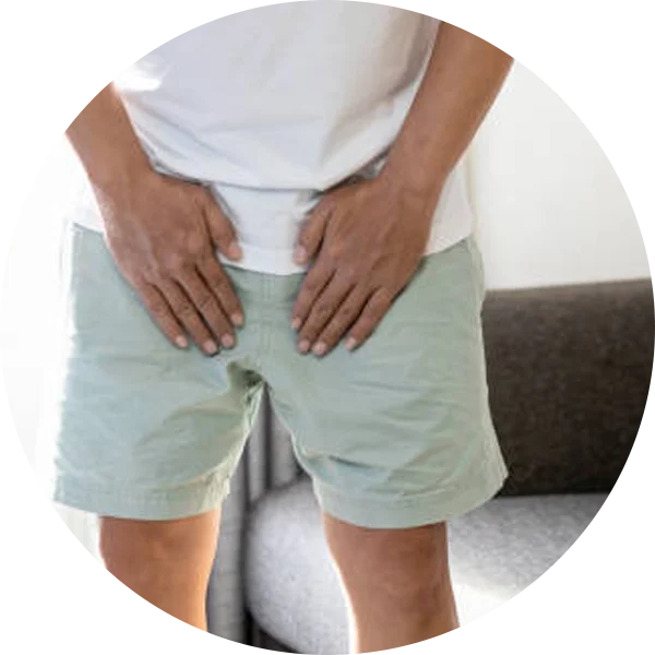 Person holding the perianal area to indicate painful swelling near the anus.