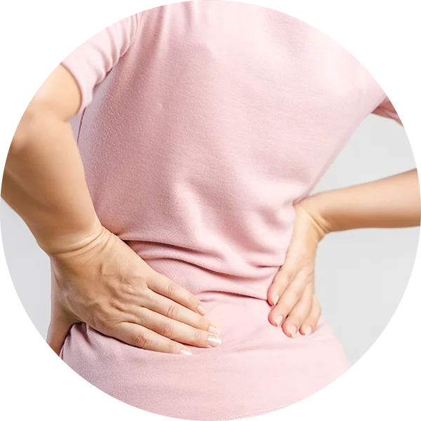 Person pressing lower back to show stiffness in the back and hips from sciatica.